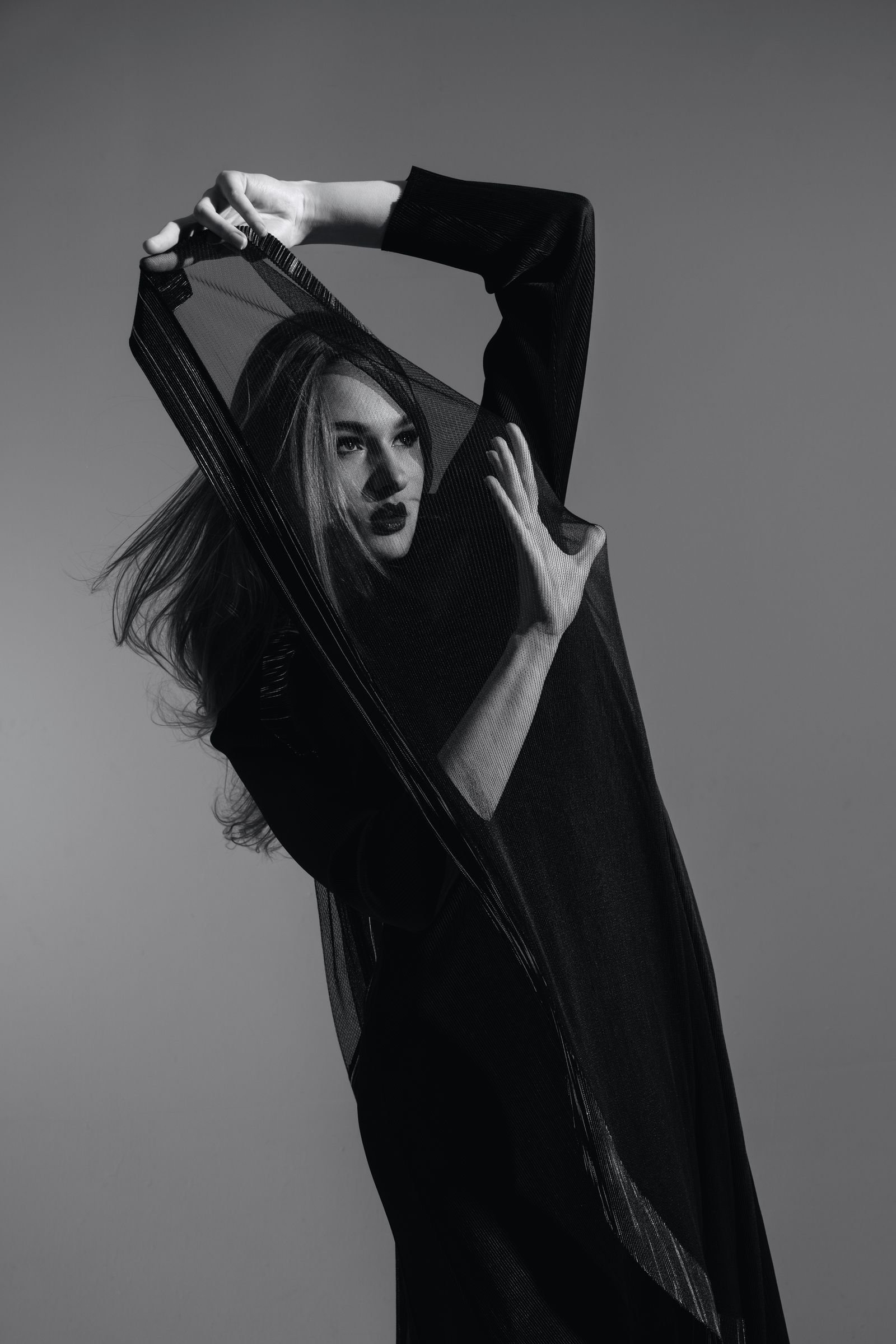 A black and white editorial fashion portrait in a studio